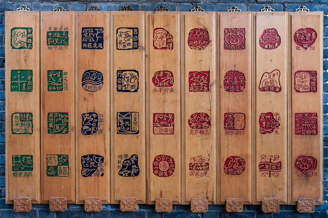 Lijiang, Yunnan, China: Billboard with Dongba hieroglyph characters