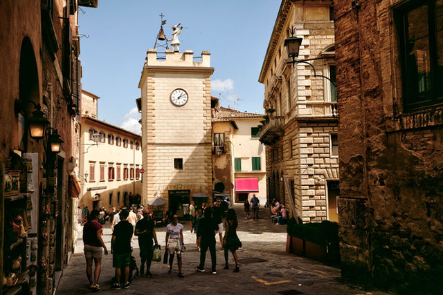 Explore the historic and charming streets of Montepulciano, Tuscany, with its iconic clock tower and old town vibe.