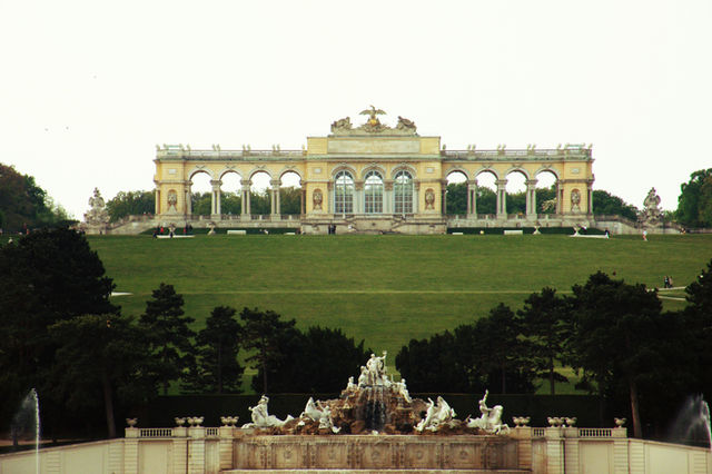 Grand palace with arched facade on grassy hill