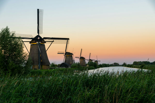 Windmills along a canal at Kinderdijk during the golden hour