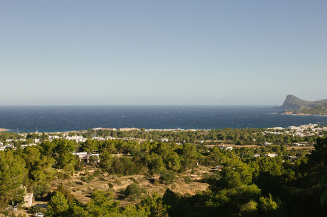 A breathtaking view of Ibiza's coastline with lush greenery and the Mediterranean Sea.
