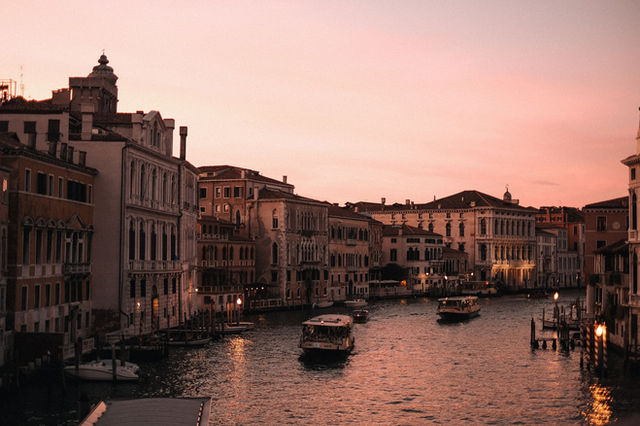Experience the serene beauty of Venice's canals at sunset, highlighting classic architecture and gentle waters.