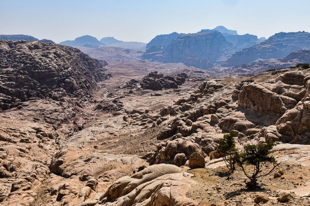 Breathtaking view of arid desert landscape and rocky formations under the bright sun in Jordan.