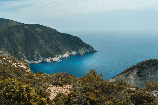 Breathtaking view of the Zakynthos coastline with lush hills and azure sea under a clear sky.