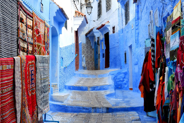 Explore the vibrant alleyways of Chefchaouen, featuring traditional textiles and blue architecture.
