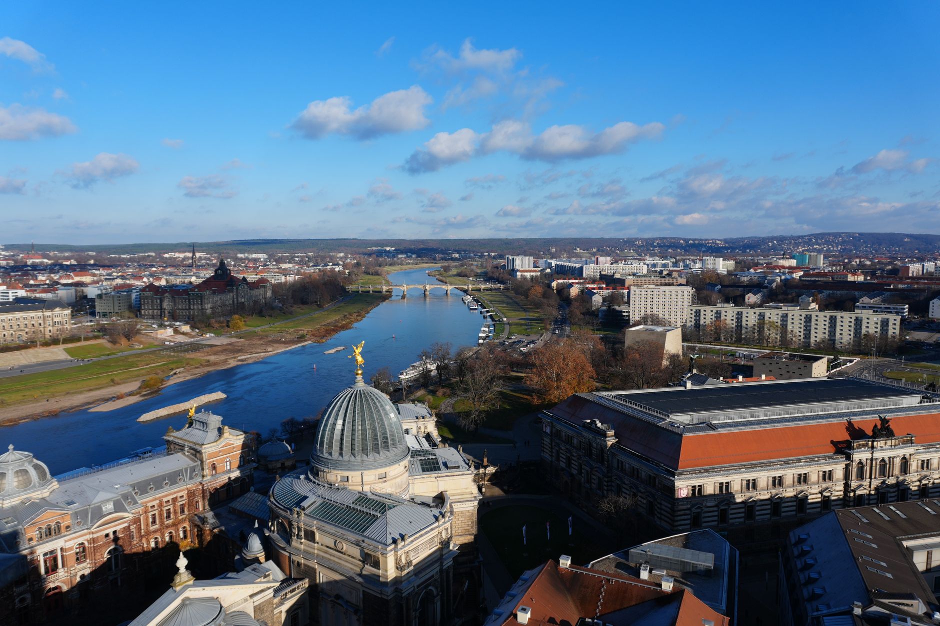 The Frauenkirche and Baroque rooftops of Dresden's old town reflected in the River Elbe at sunset