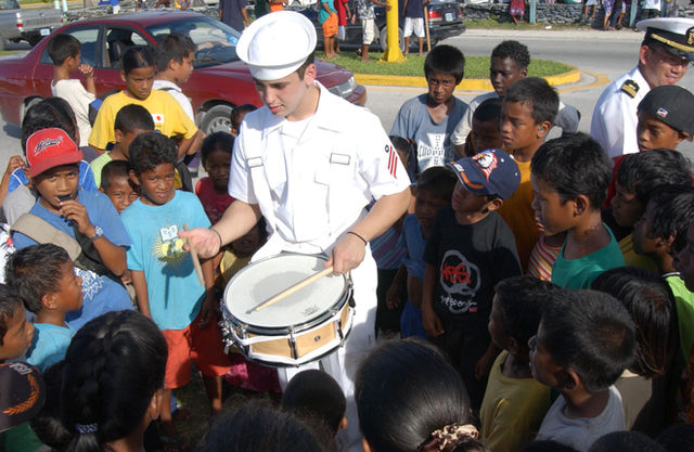 Majuro, Mashall Islands (Aug. 25, 2005) - Engineman Fireman Andy Davis plays the drums for local children in Majuro, Marshall Islands after participating in a parade. The visit wil