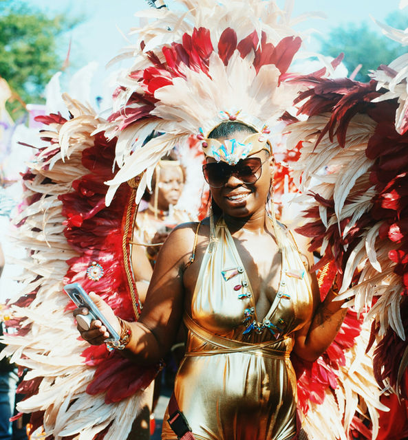 Gold halterneck against a wall of red and white feathers