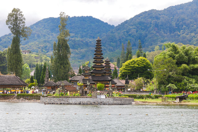 Ulun danu beratan temple on a lake with mountains.