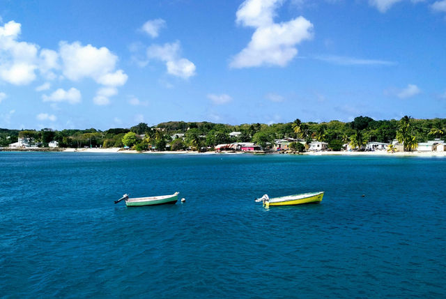 two empty boats on body of water near island with houses