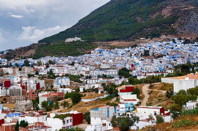 A vibrant panorama of Chefchaouen with its iconic blue buildings nestled in the mountains.