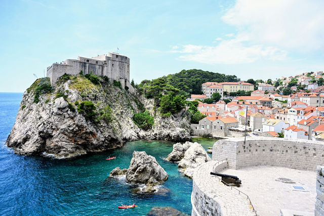 Boats gather in Dubrovnik's historic Old Port beneath centuries-old stone fortifications, where the Adriatic Sea meets one of Croatia's most iconic coastal cities.