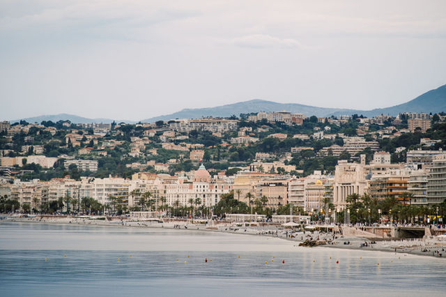 Scenic view of Nice seafront with buildings and mountains, French Riviera.
