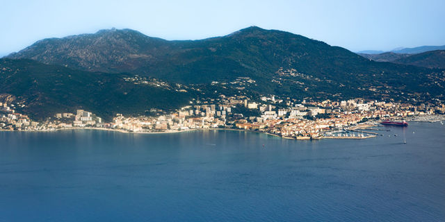 Discover the stunning aerial landscape of Ajaccio, Corsica featuring mountains and coastline.
