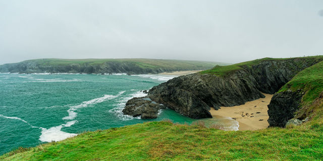 Breathtaking view of Trevaunance Cove's rugged cliffs and turquoise sea in Cornwall, England.