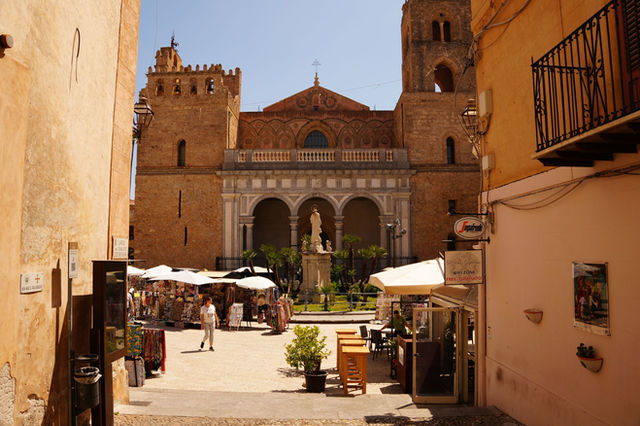 Explore the stunning Norman architecture of Monreale Cathedral in Sicily's lively street setting.