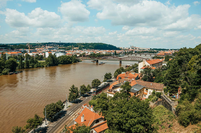 Aerial view of Prague's historical landscape featuring the Vltava River and iconic bridges.