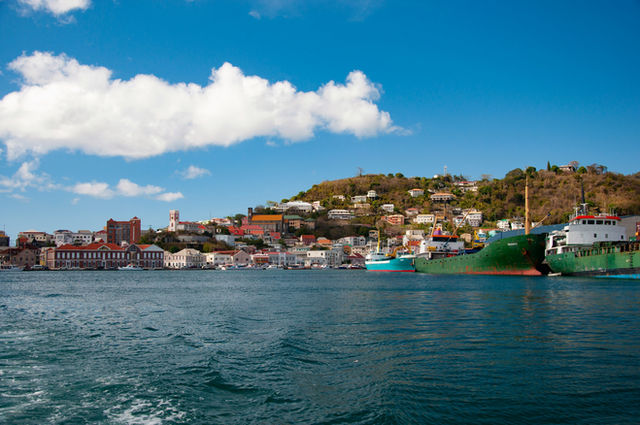 body of water near city buildings under blue and white sunny cloudy sky during daytime