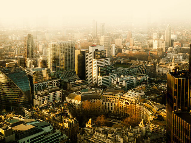 Aerial view of the City of London skyline during golden hour with iconic landmarks and modern architecture.
