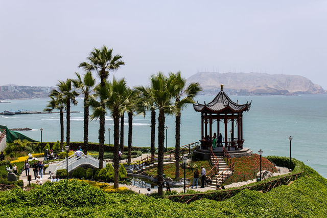 Scenic view of a gazebo surrounded by palm trees and ocean in Lima, Peru.