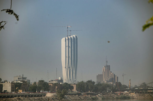 A tall white building sitting next to a body of water