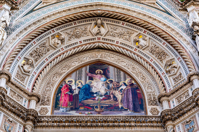 Close-up of Florence Cathedral's ornate facade showcasing religious frescoes and sculptures in Tuscany, Italy.