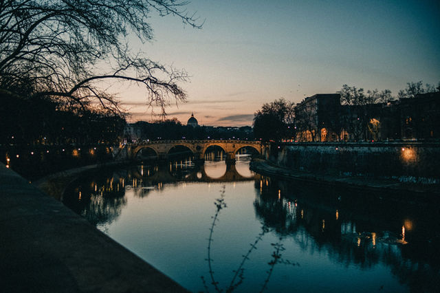 Twilight view of Ponte Sisto reflecting in the Tiber River, capturing Rome's enchanting charm.