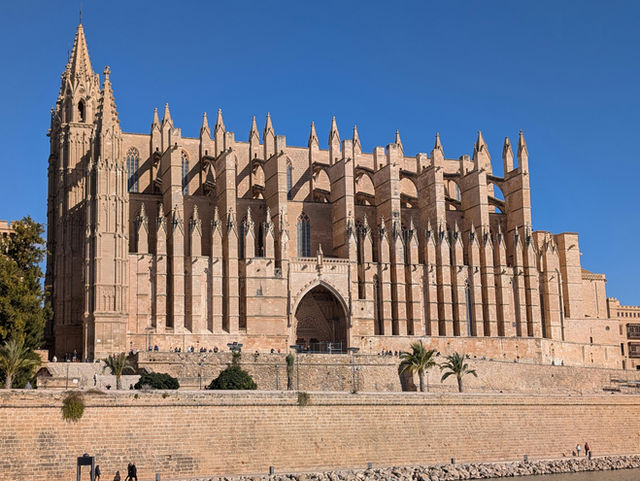 A grand gothic cathedral with intricate spires under blue sky.
