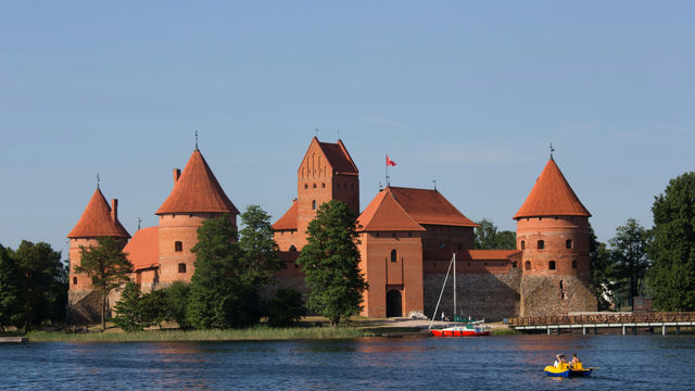 a boat is in the water in front of a castle