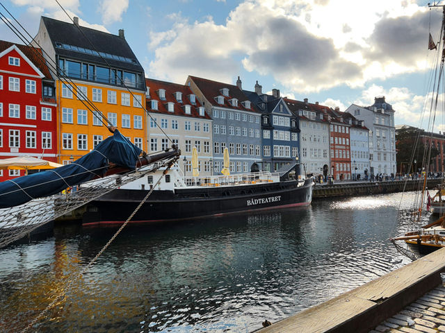 Colorful buildings line a canal with a docked ship.