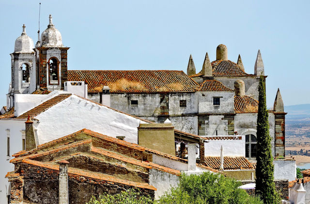 View of the historic Monsaraz Castle with scenic surroundings in Portugal's Alentejo region.