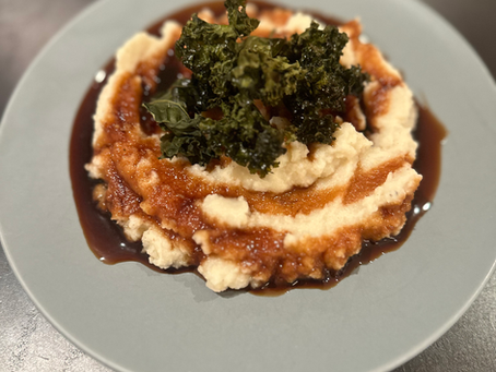 Cauliflower puree with a drizzle of pomegranate molasses and roasted kale.