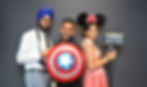 Three friends costumed posing in front of a photobooth