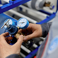 A metrology laboratory specialist takes a compressed gas cylinder for testing and verifica