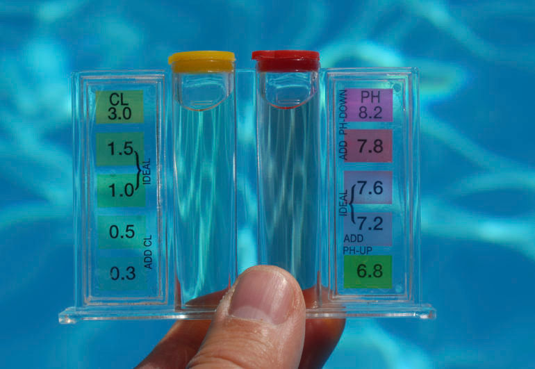 Close-up view of pool water testing kit with test strips