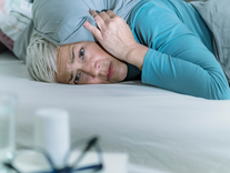 An overwhelmed woman resting in bed.
