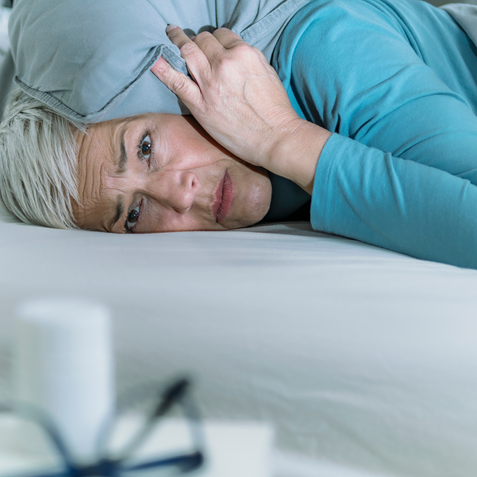 An overwhelmed woman resting in bed.