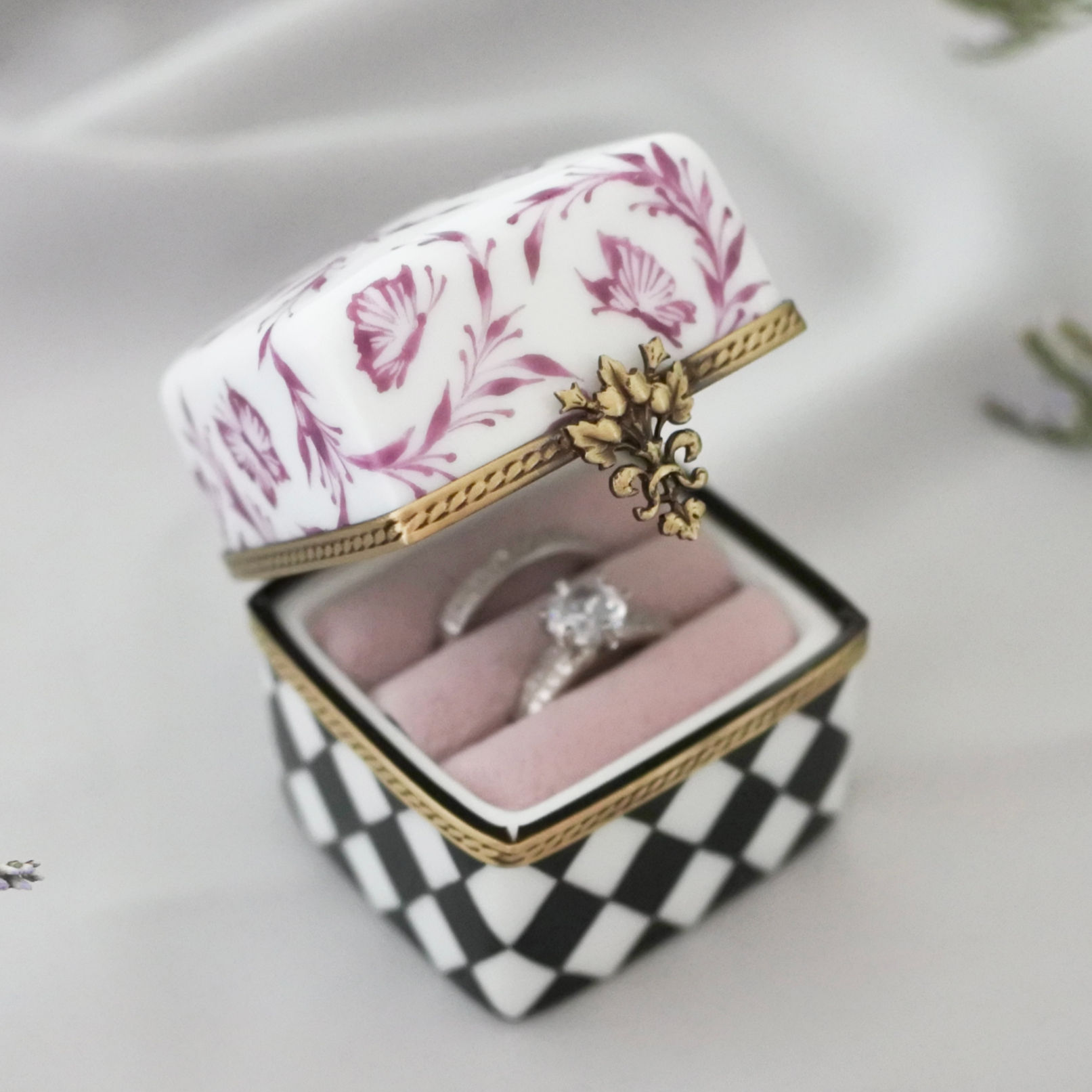 Front view of handmade porcelain ring box open, showing rings inside