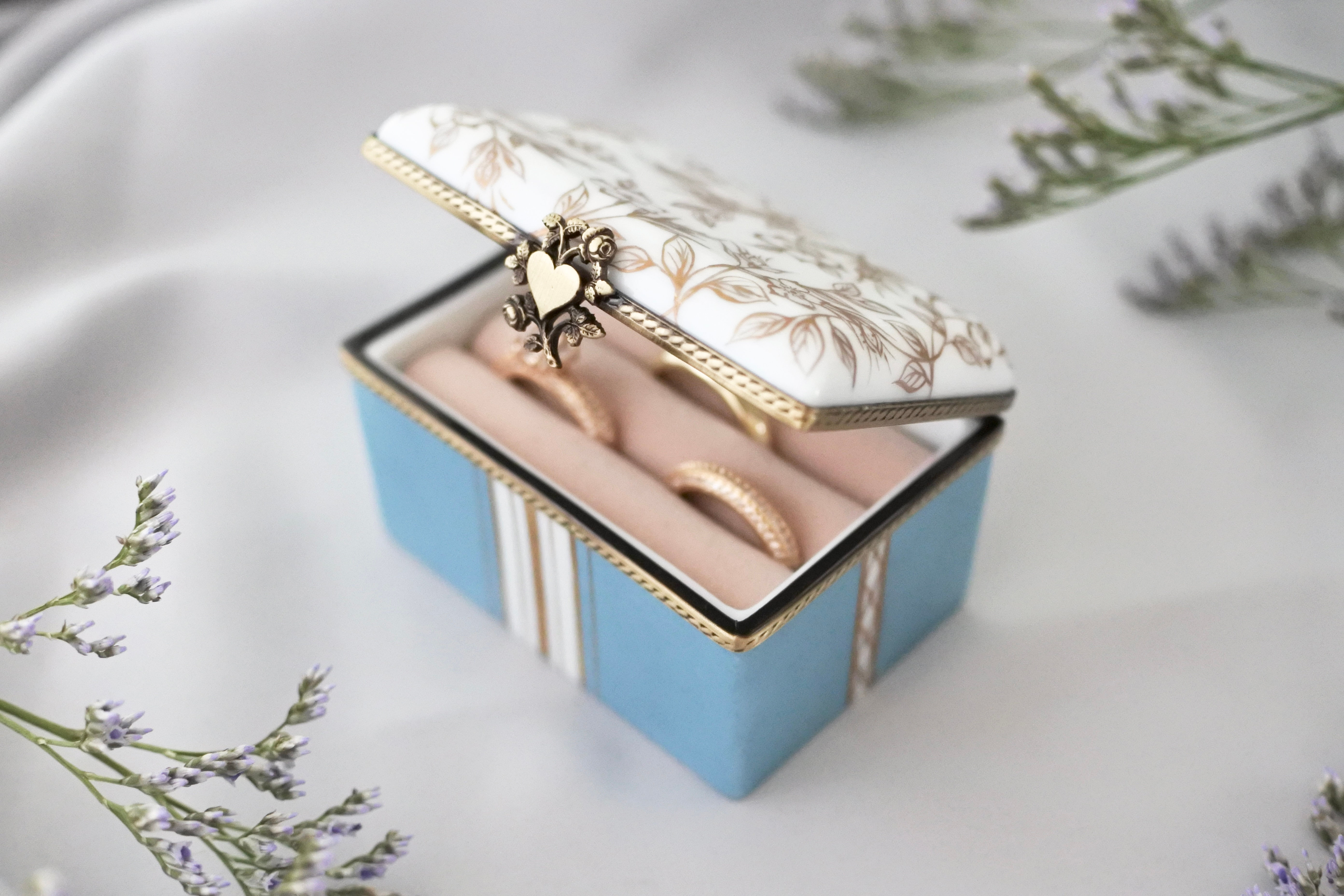 Front view of handmade porcelain ring box slightly open, showing ring inside