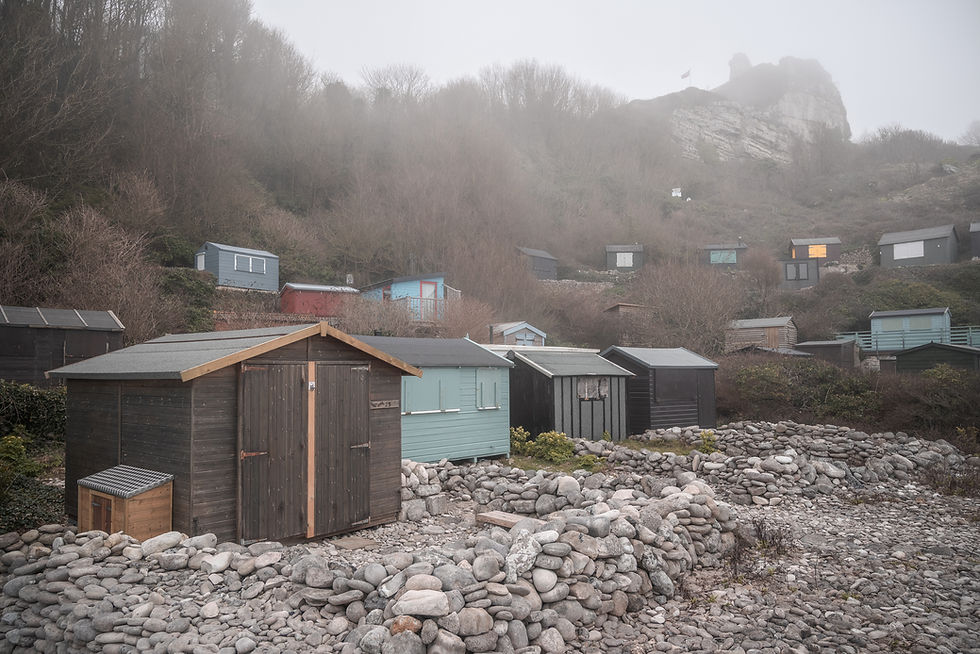 Beach huts with dry stone walls in front of them on Church Ope Cove, Portland