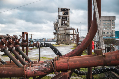 Rusting industrial pipework on a disused wharf on the River Thames by Nortfleet