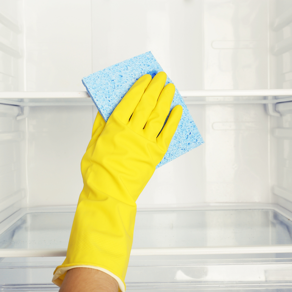 Hand with cleaning glove using a sponge to clean inside a fridge.