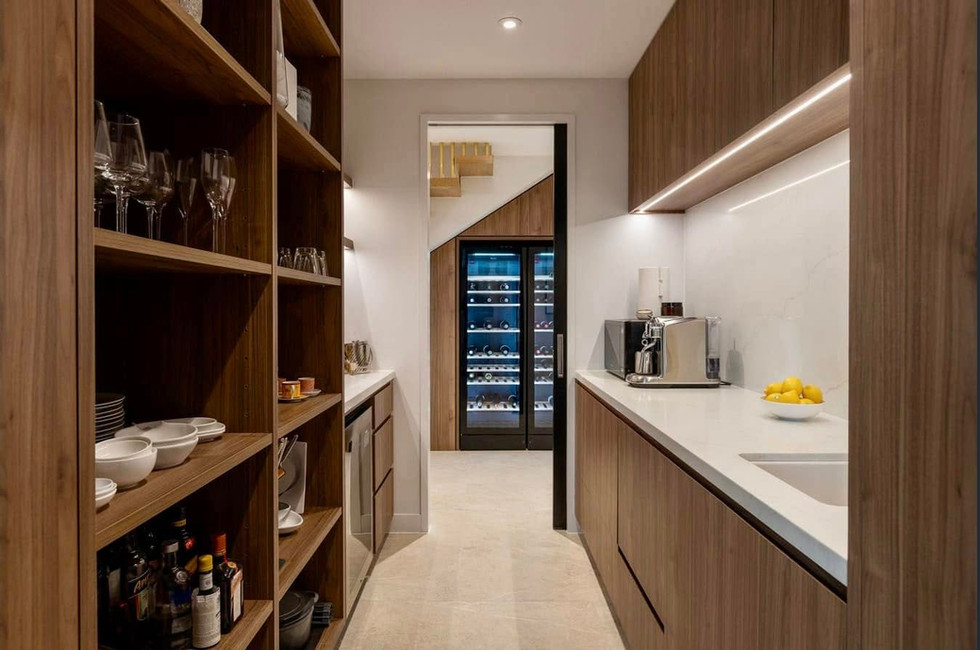 Butlers panty with custom cabinets looking out to a luxury built-in wine cabinet