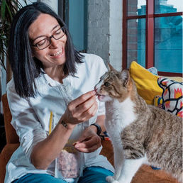 Mikel Maria Delgado playing with a cat.