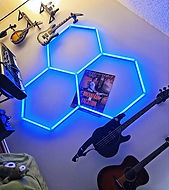 A wall with a mandolin, electric guitar, bass guitar, and acoustic guitar hanging