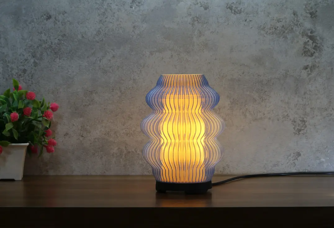 Noir Ripple lamp illuminated and highlighting the wavy texture and warm light
