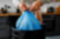 housewife-tying-knot-on-blue-plastic-garbage-bag-in-kitchen-photo.jpg