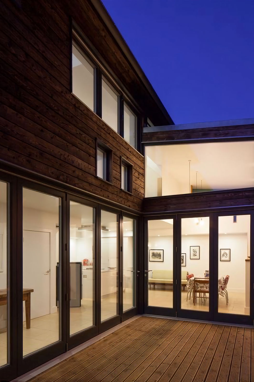 Modern residential extension with glass walls and timber cladding designed by AKS Structures