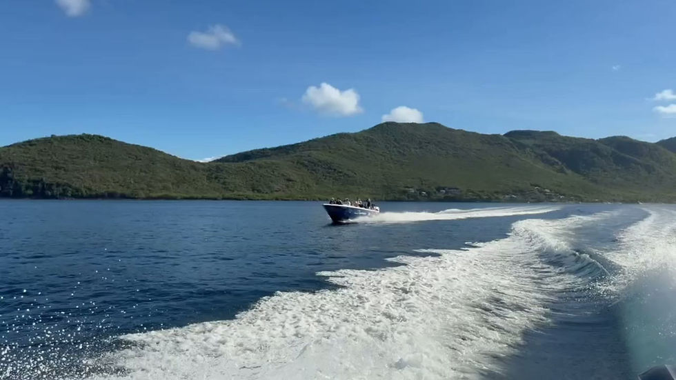 Bateau à moteur filant le long d'une côte boisée, sillage au premier plan