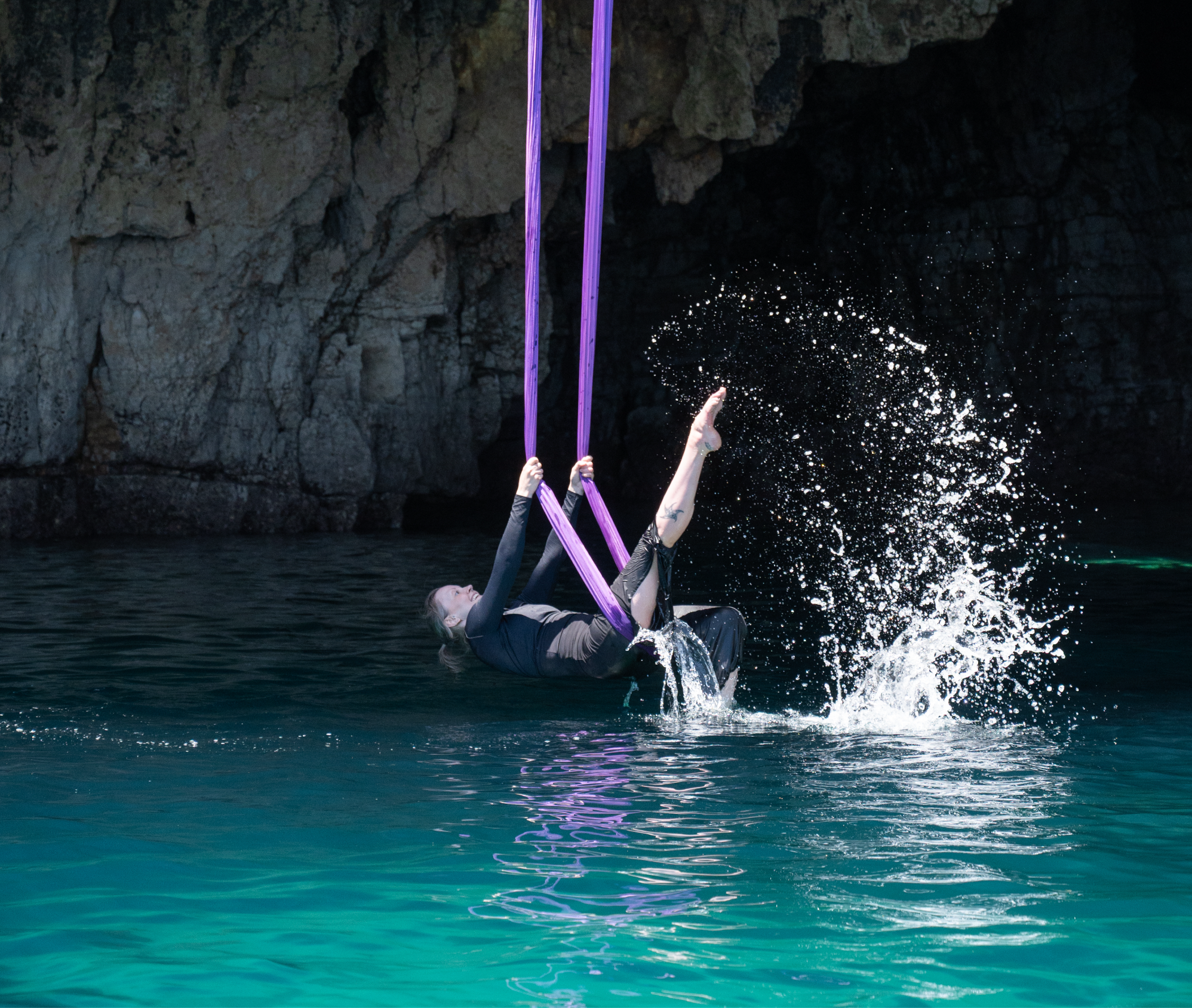 Petra Kalliommaa performing a technical sling movement against a coastal backdrop.